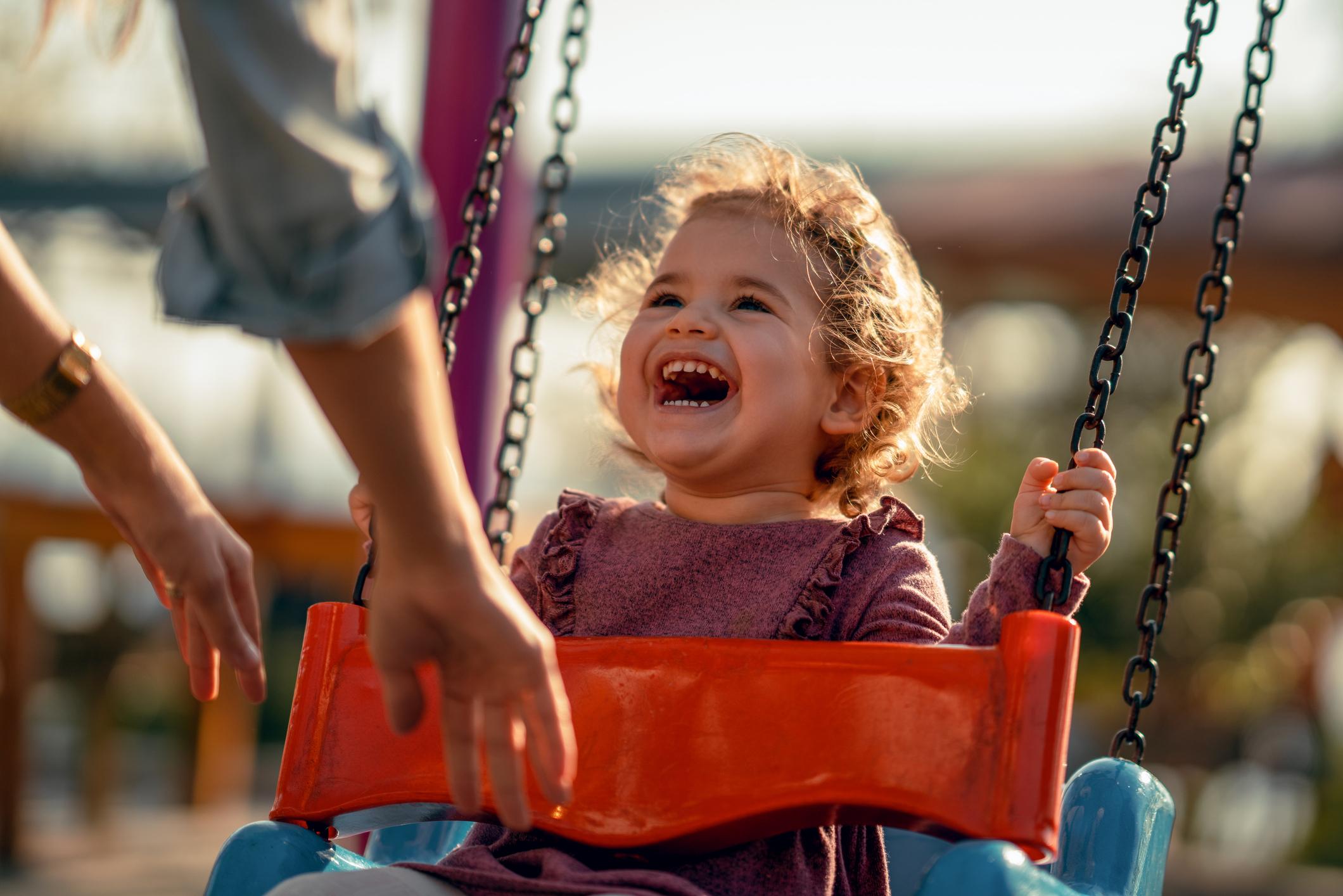 Adorable little girl having fun on a swing.